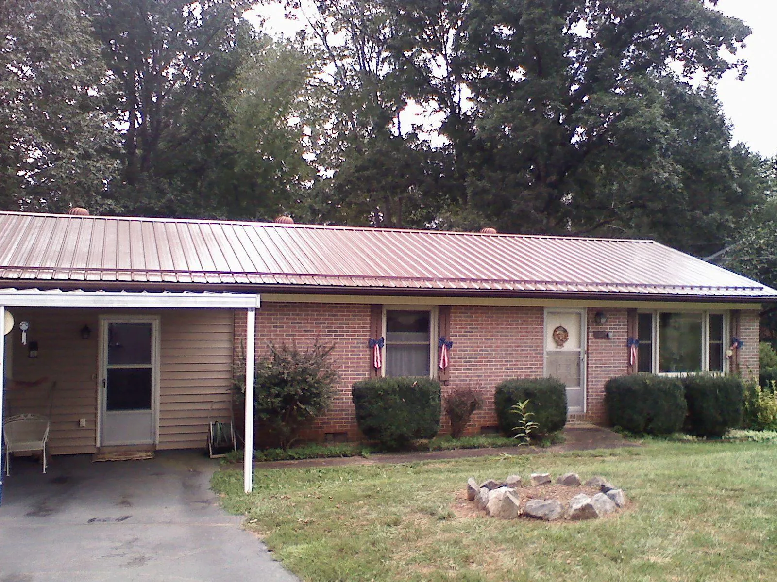 Bronze metal roof and carport on a brick ranch home — Roof Repair work by our crew in Volcano